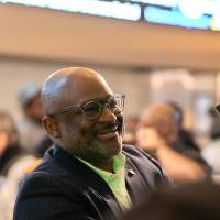 Man smiling at someone at his table sitting off camera